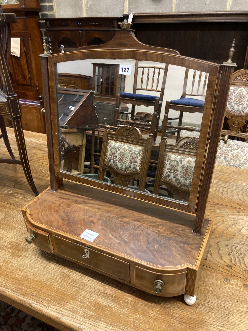 A George III mahogany and tulipwood banded bowfronted toilet mirror, on ivory ball feet, width 54cm depth 23cm height 60cm